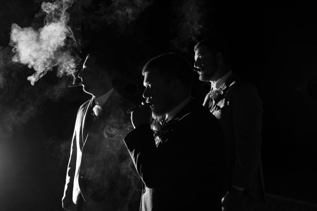 Groom and groomsmen take a cigar break during the reception